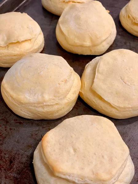 Golden, fluffy biscuits just out of the oven on a baking sheet