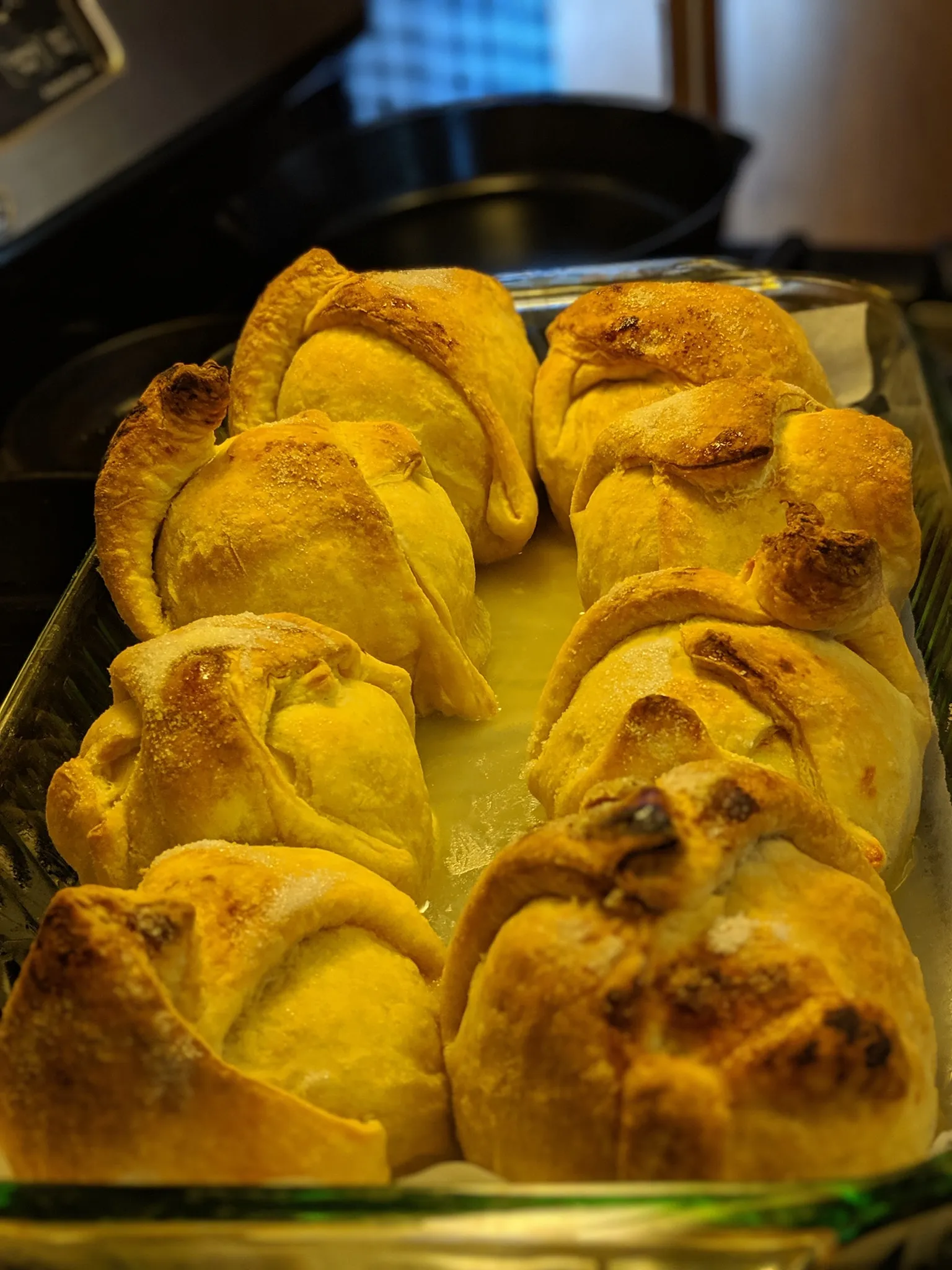 Apple dumpling cut open on plate, steam rising, vanilla ice cream melting alongside