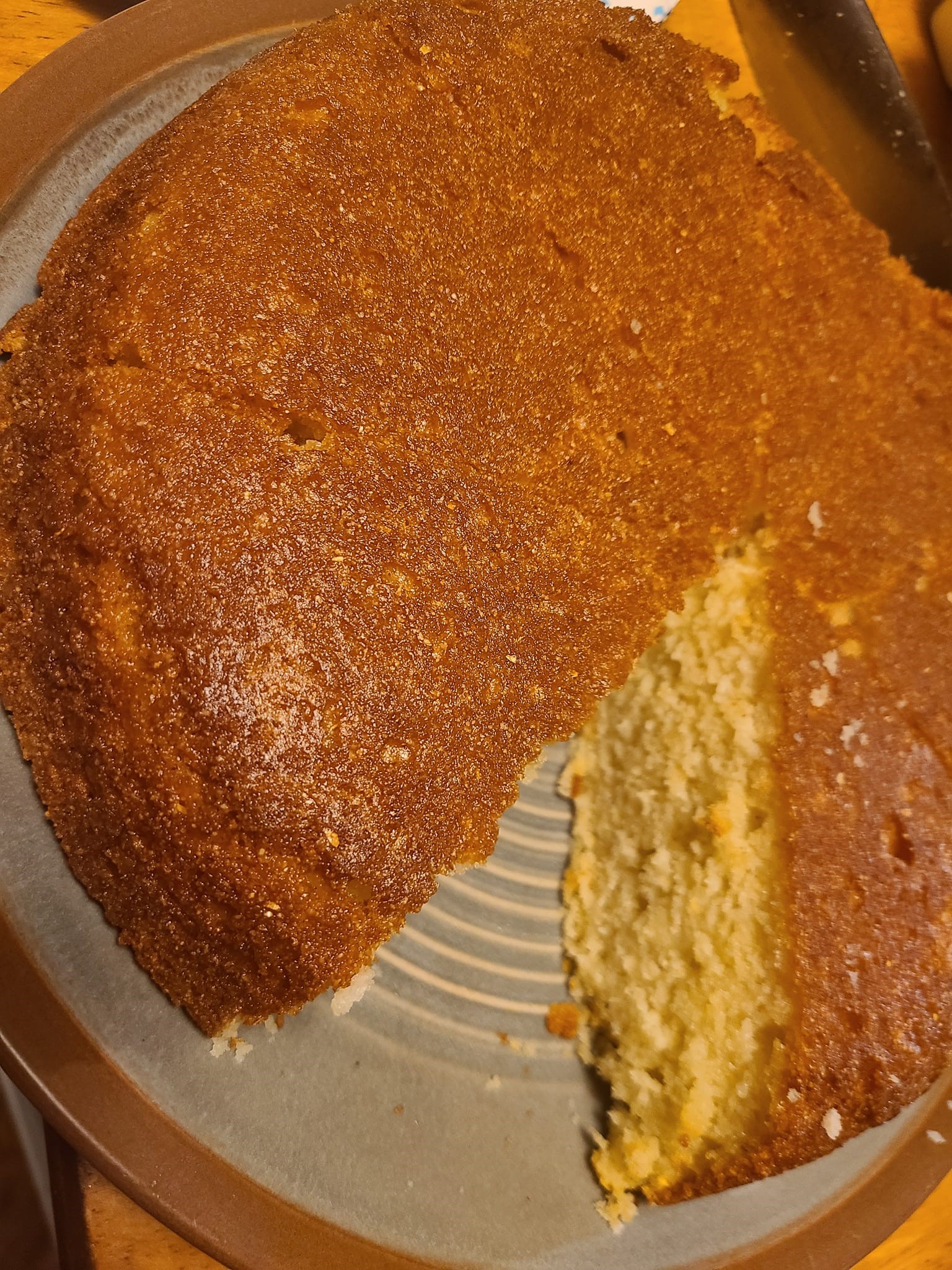 A sliced piece of aunt's mayonnaise cornbread on a plate, showing its soft texture inside.