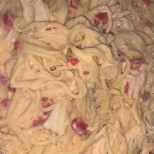 Cheesy chicken spaghetti casserole in a baking dish, golden and bubbly