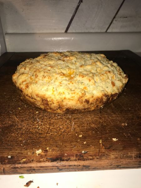 Golden, fluffy cast iron cheesy beer bread cooling on a wooden cutting board – easy skillet beer bread recipe