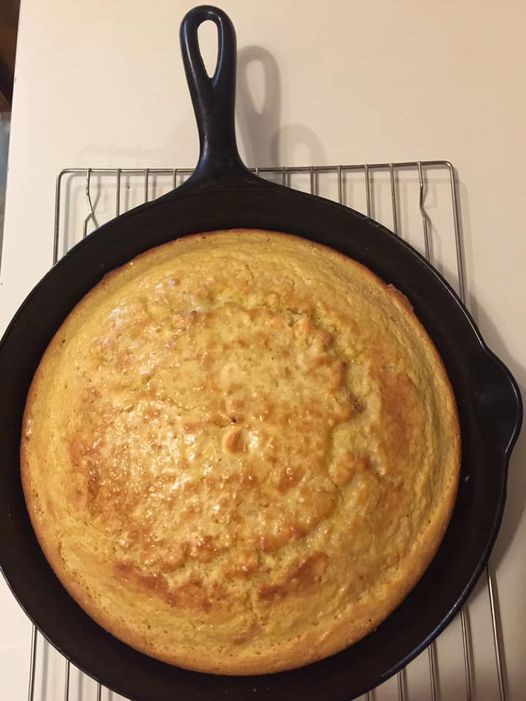 Golden brown traditional Southern cornbread baked in a cast iron skillet, cooling on a wire rack.