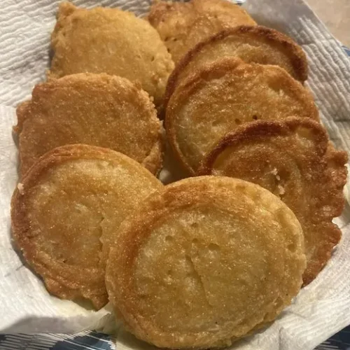 : Fresh corn meal cakes sizzling in a cast iron skillet