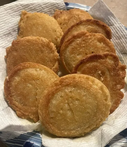 : Fresh corn meal cakes sizzling in a cast iron skillet