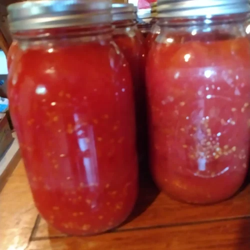 Homemade tomato soup simmering in a pot; creamy tomato soup served in a bowl with basil.