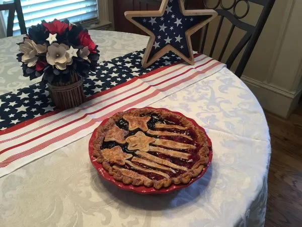 Tweezers adding star sprinkle to blue corner of pretzel.