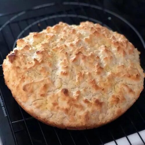 Biscuit bread baked in a cast iron skillet; slice of pone bread with butter.