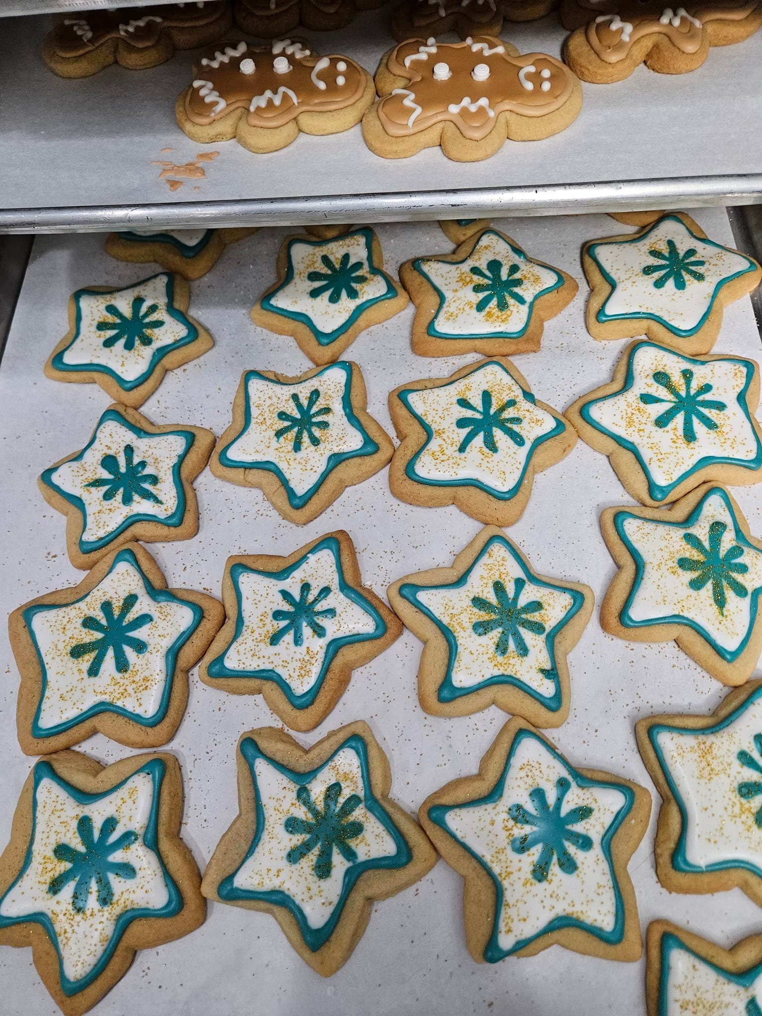 Festive star-shaped sugar cookies decorated with blue icing and gold accents.