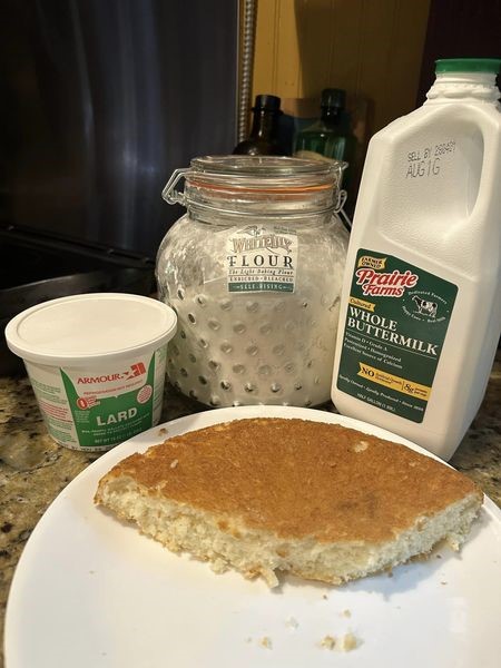Golden skillet biscuit bread (pone bread) sliced and served with sorghum syrup on a checked tablecloth – easy biscuit bread recipe