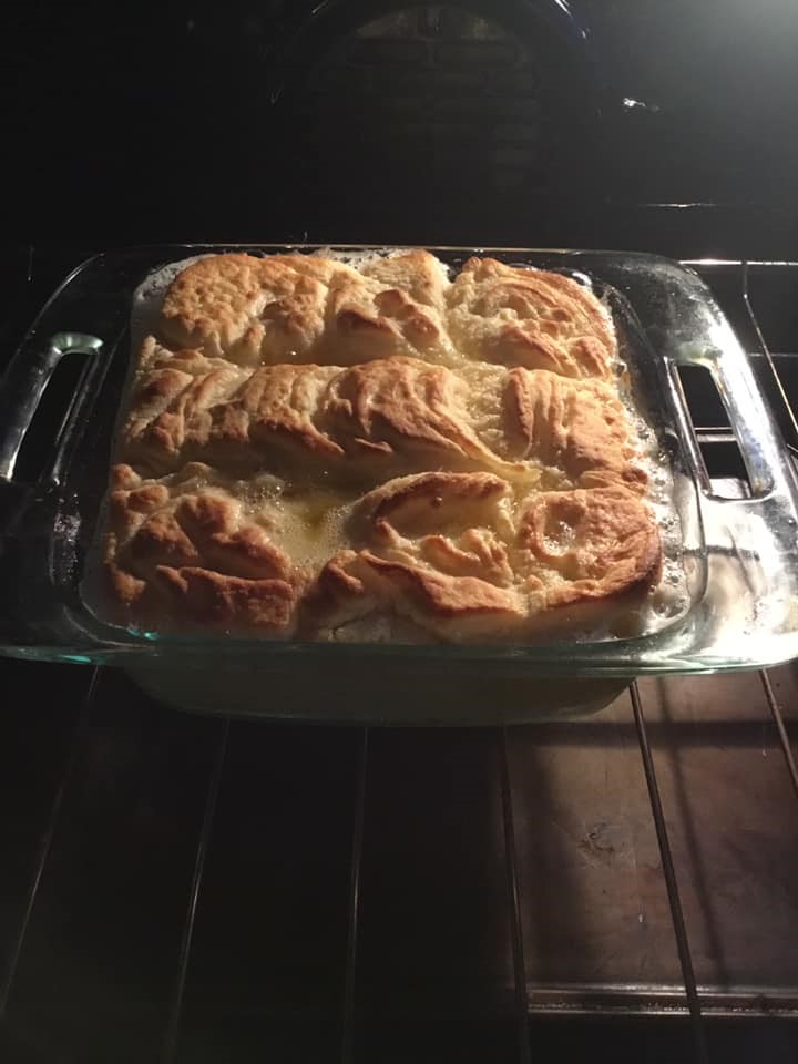 Freshly baked butter swim biscuits in a glass dish, golden brown with bubbling butter around the edges – butter swim biscuits recipe