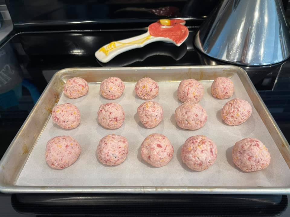 Golden-brown cream cheese sausage balls fresh out of the oven on a baking sheet