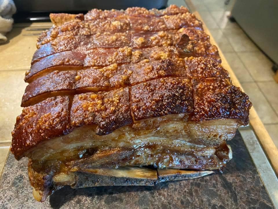 Whole pork rib roast with golden, crunchy skin, freshly roasted.