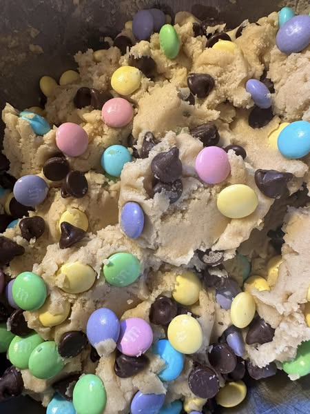 Cookie dough with colorful M&Ms and chocolate chips mixed in.