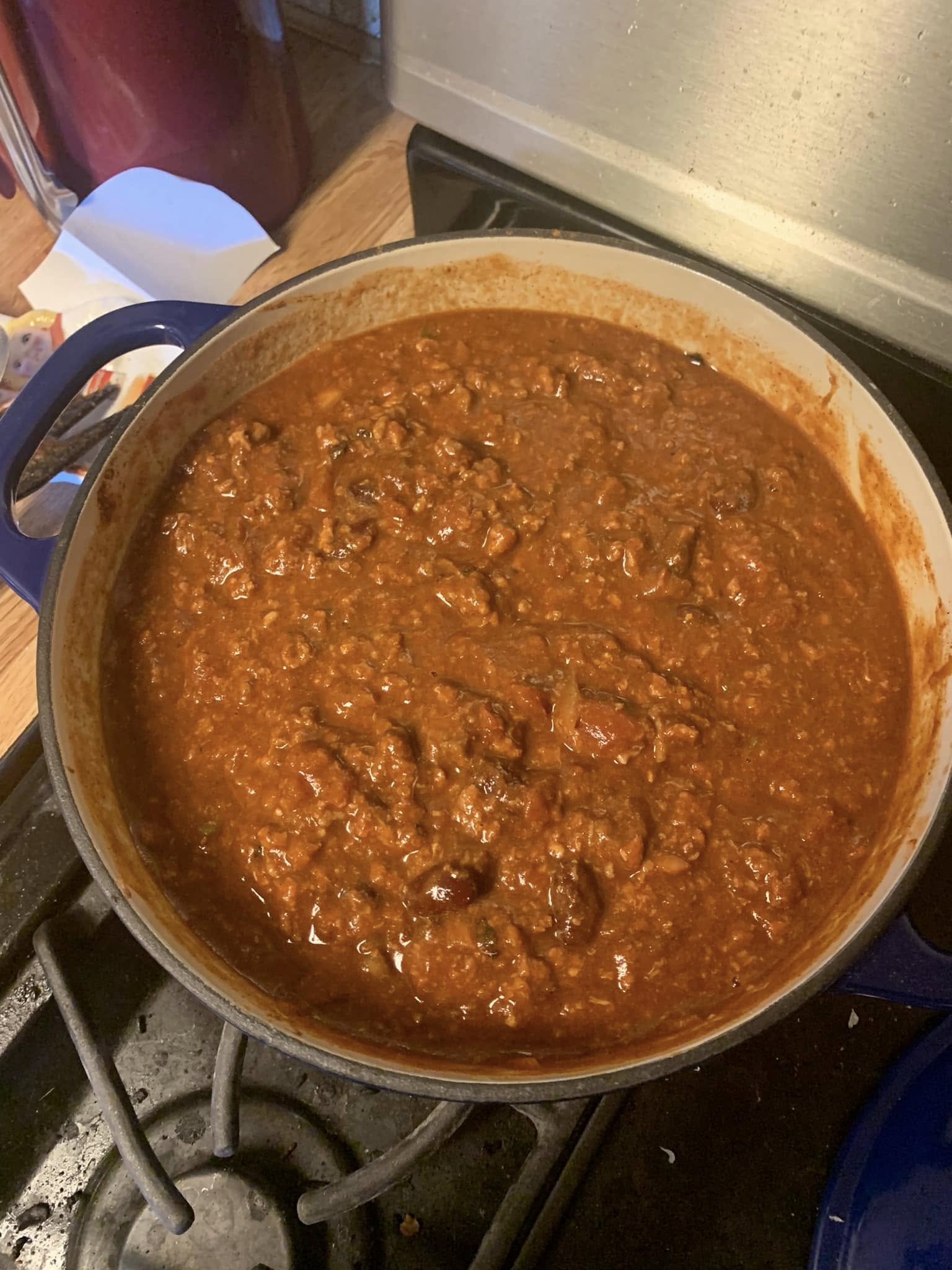 A pot of hearty homemade chili with tender meats, beans, and a flavorful tomato base