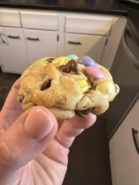 A large scoop of M&M chocolate chip cookie dough ready to bake.