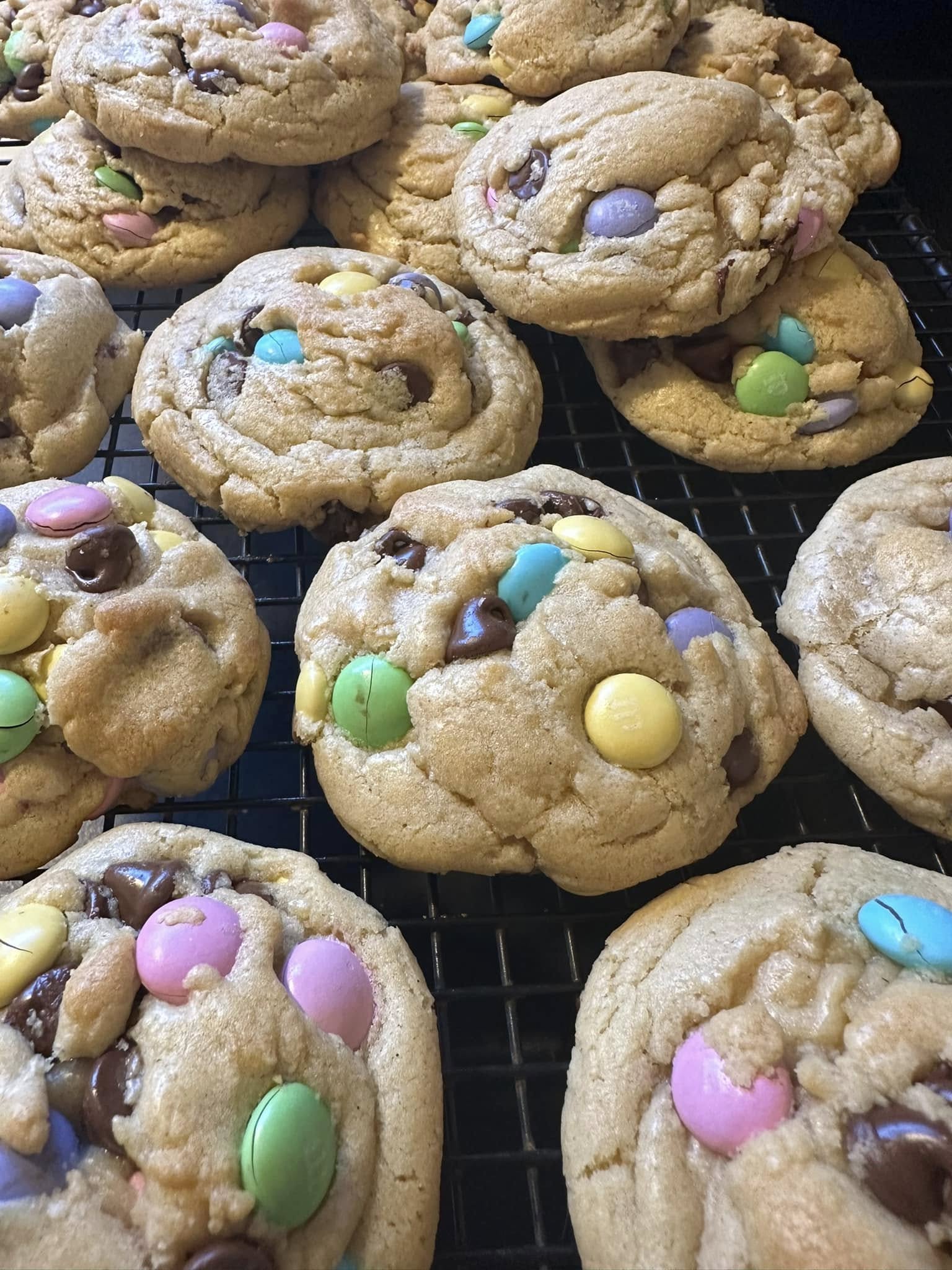 Freshly baked M&M chocolate chip cookies cooling on a wire rack