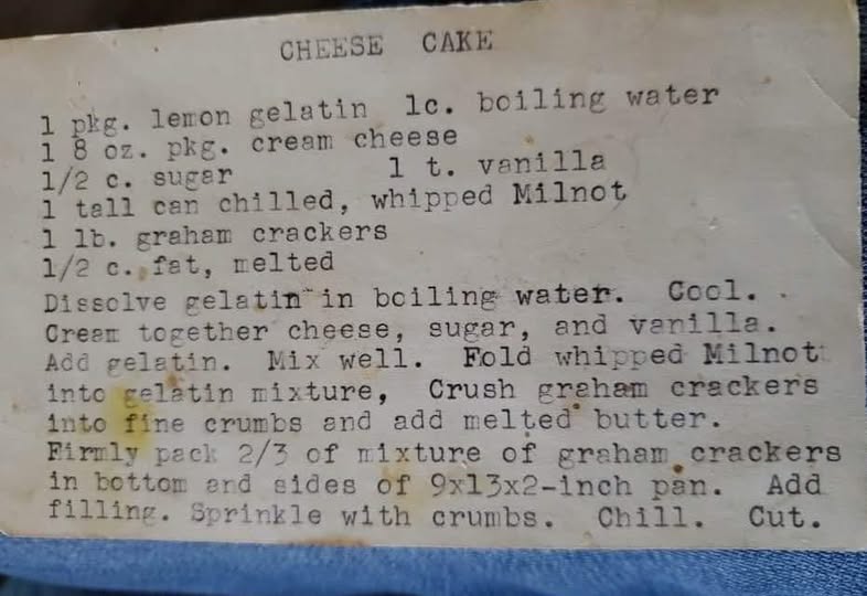 A vintage recipe card for cheesecake from 1956, handwritten and slightly aged.”