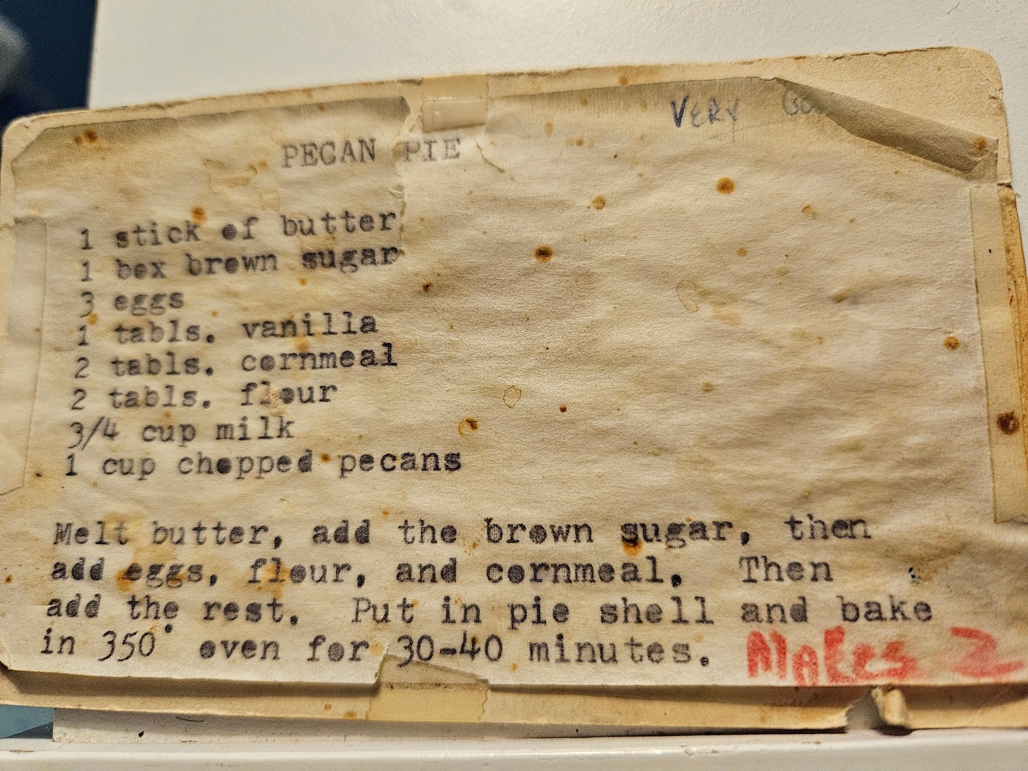 A vintage pecan pie recipe card, typed and slightly stained, featuring a corn syrup-free custard-style filling.