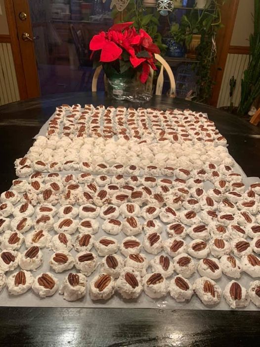 Homemade divinity candy arranged on parchment paper, each piece topped with a pecan, ready to enjoy.