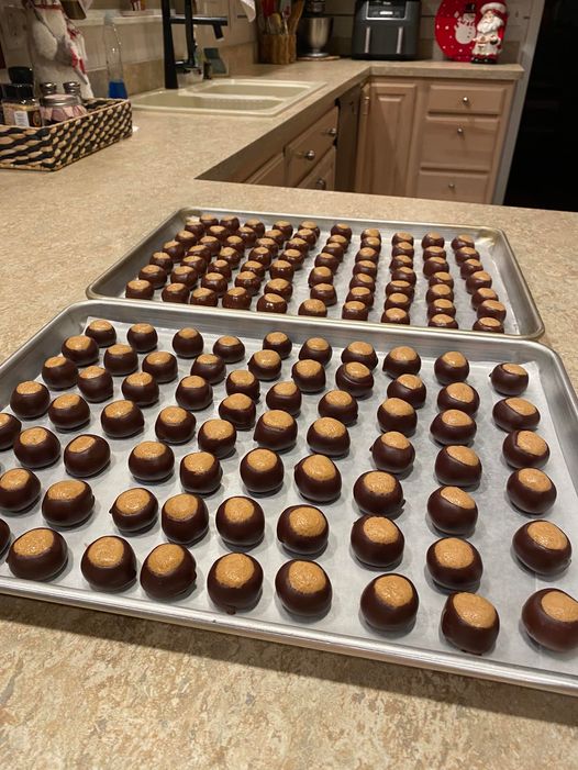 "Dippin Buckeyes lined up on wax paper with a shiny chocolate coating and creamy peanut butter center