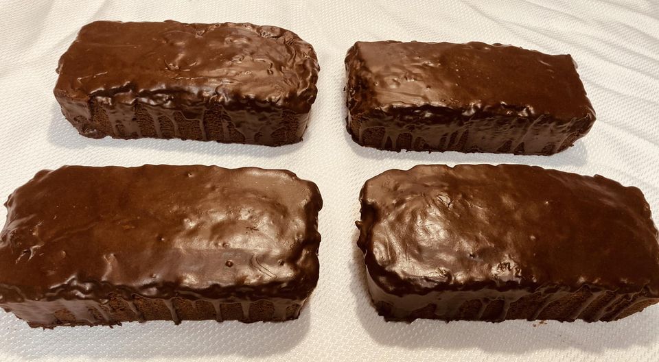 Four glossy chocolate pound cakes ready to serve