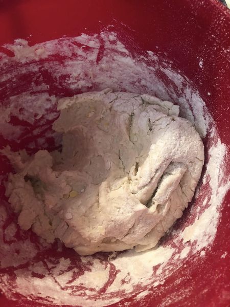 Dumpling dough in a red bowl, ready for spooning into the pot.