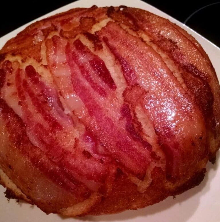 Golden bacon-topped cornbread flipped out of a cast iron skillet, crispy bacon glistening on top