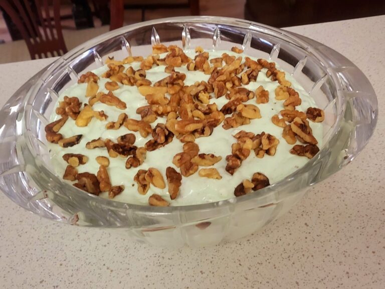 Lime jello salad in a crystal serving bowl, topped with crunchy walnuts, chilled and ready to serve