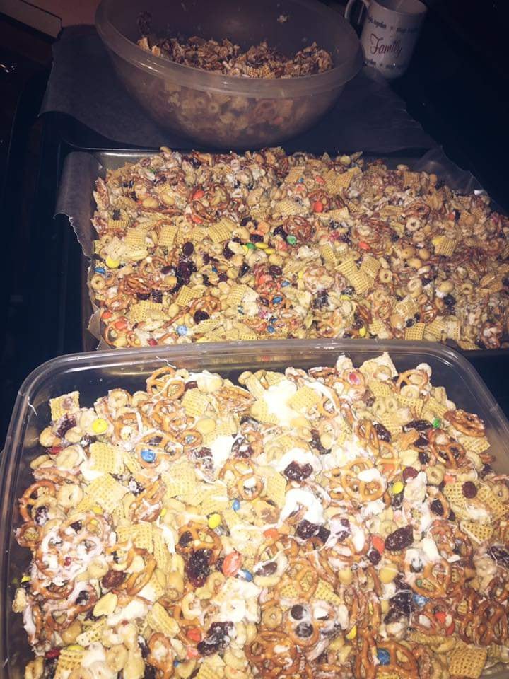 Baking trays lined with wax paper holding freshly made Christmas Crack Snack Mix