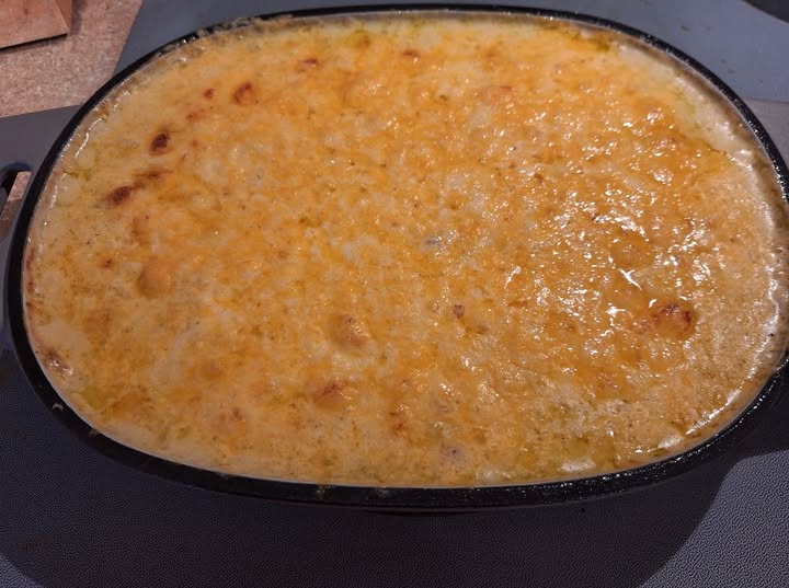 A golden Christmas Hominy casserole with bubbly cheese on top, fresh from the oven