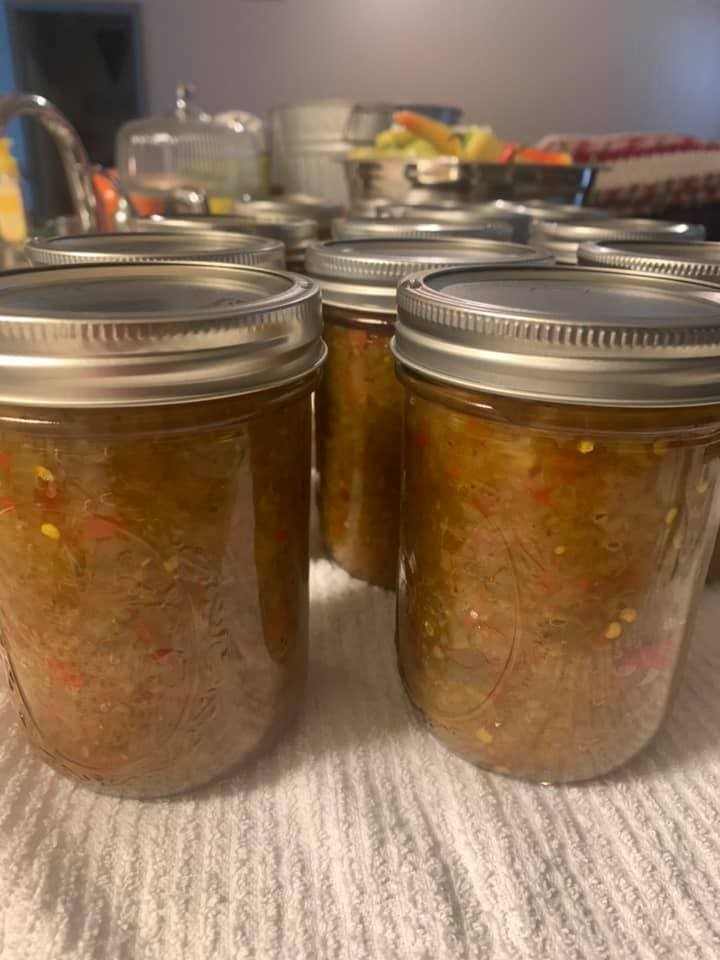 Jars of freshly canned Southern chow chow cooling on a towel, ready for storage.