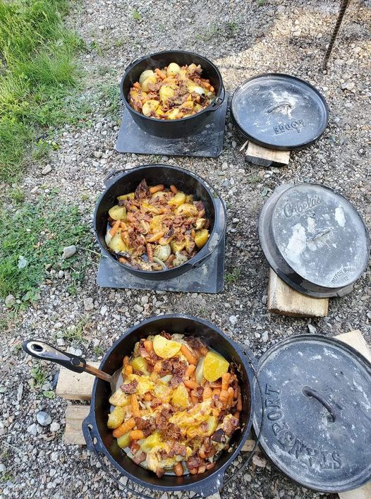 Mountain Dew Chicken cooked in a Dutch oven, topped with melted cheese and surrounded by vegetables