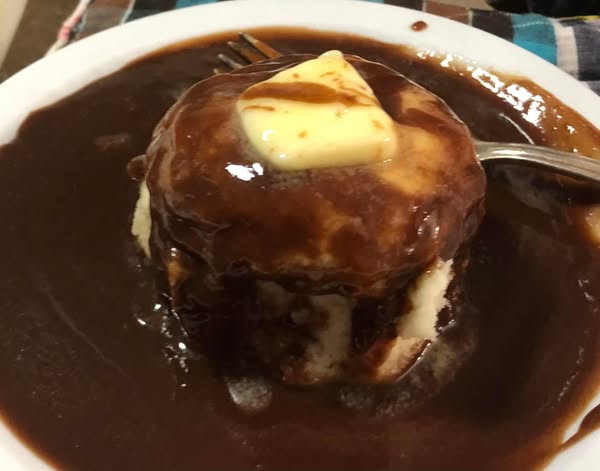 A warm biscuit smothered in rich chocolate gravy, topped with a melting pat of butter.