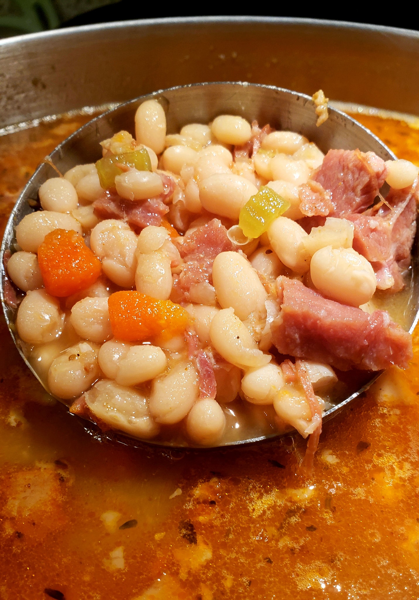 Ham bone simmering in a stockpot with herbs, creating rich broth