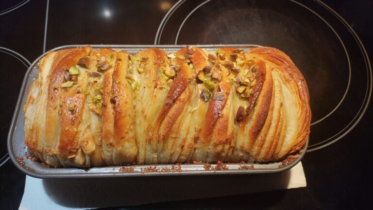 Spicy honey butter pull-apart garlic bread with melted pepper jack cheese, crispy fried onions, and a honey drizzle in a white loaf pan