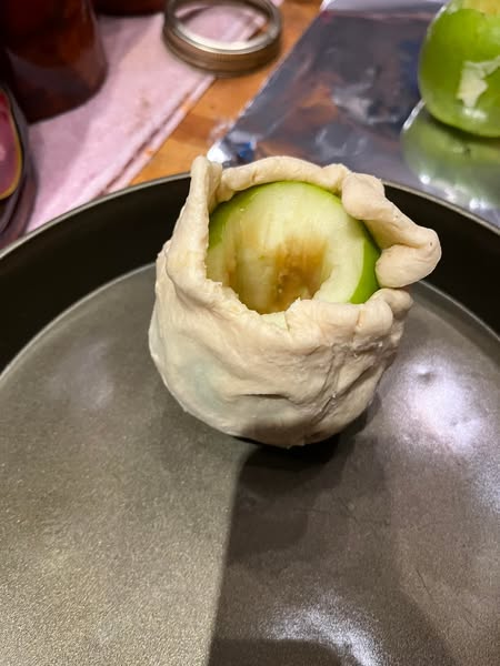 Fresh apples wrapped in crescent roll dough, ready to be baked into apple dumplings