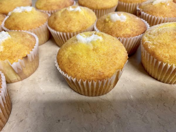 lose-up of freshly baked Pina Colada cupcakes, showcasing their golden-brown tops with a creamy coconut filling peeking through