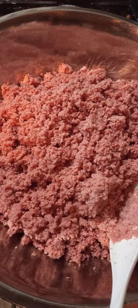 A bowl filled with finely ground bologna, ready to be mixed into a creamy sandwich spread.