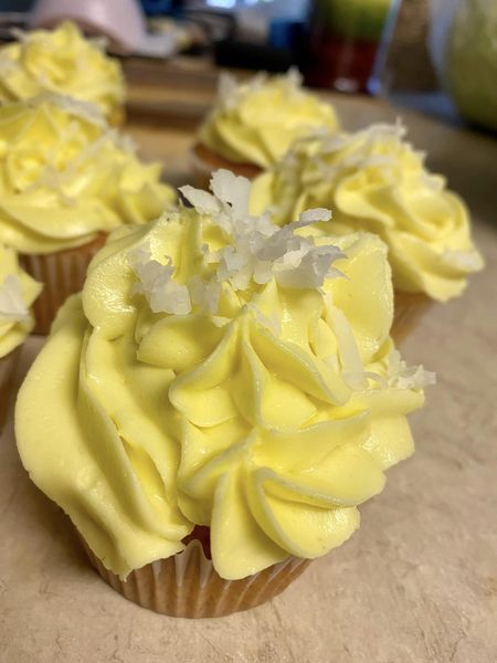 Pina Colada cupcakes with coconut topping on a white plate