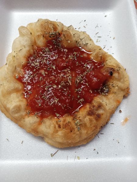 A plate stacked with freshly fried golden-brown fry bread, crispy and ready to serve