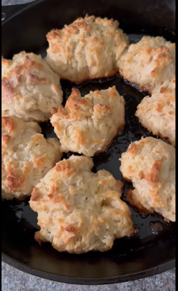 Golden-brown drop biscuits in a Lodge cast iron skillet, hot and ready to serve