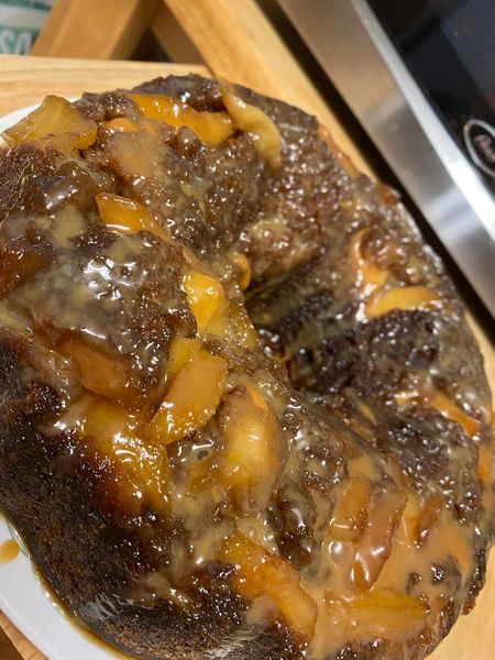 Close-up of caramel-coated apples on top of a moist apple cake