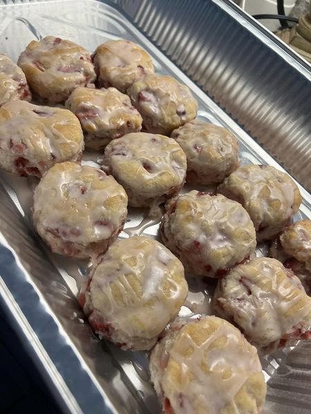 Freshly baked strawberry biscuits cooling in a baking tray.