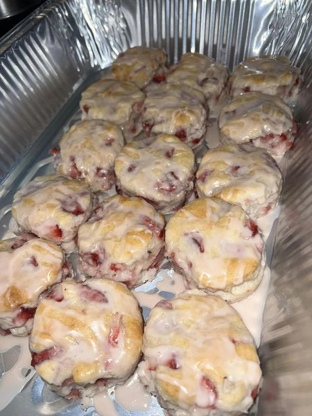 Freshly baked strawberry biscuits with a sweet glaze, arranged in a metal tray.