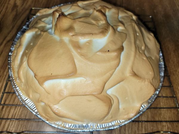 A homemade chocolate meringue pie with a fluffy golden-brown topping.