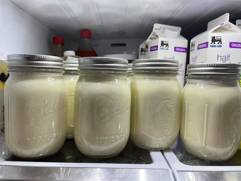 Mason jars filled with homemade eggnog chilling in the refrigerator