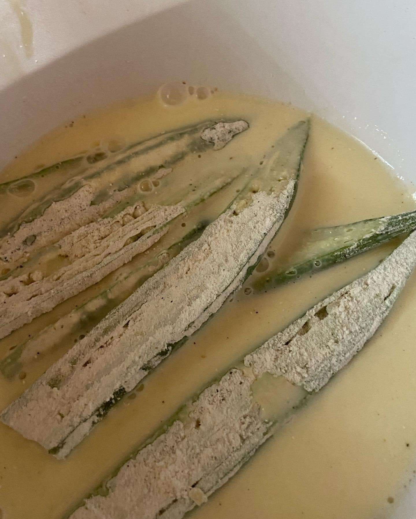 Fresh okra pieces dipped in an egg and buttermilk mixture with hot sauce for added flavor.