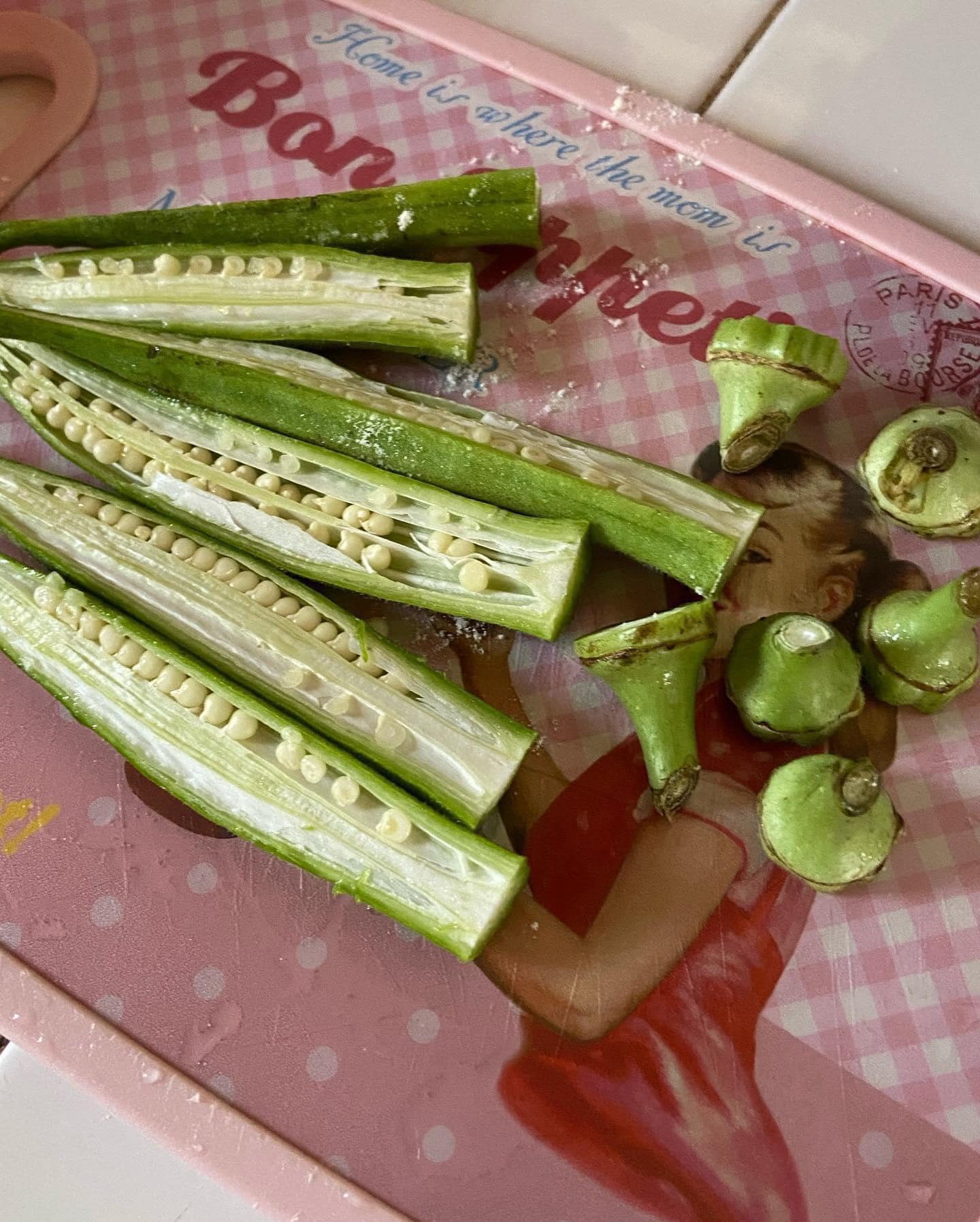 Fresh okra sliced in half, showing the seeds inside, ready for battering.