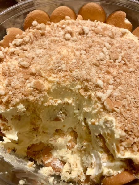 A large bowl of layered banana pudding with vanilla wafers pressed along the sides.