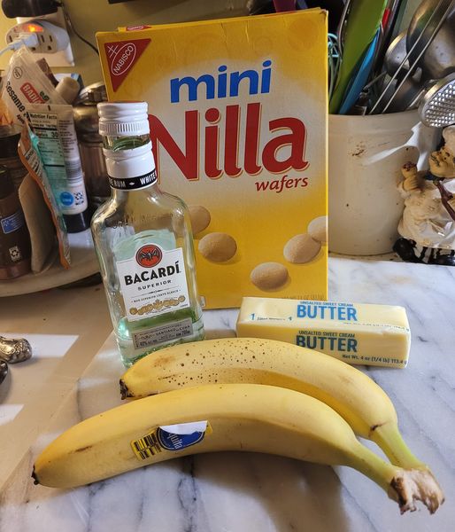 Ingredients for rum-fried bananas, including bananas, butter, brown sugar, vanilla wafers, and Bacardi rum.